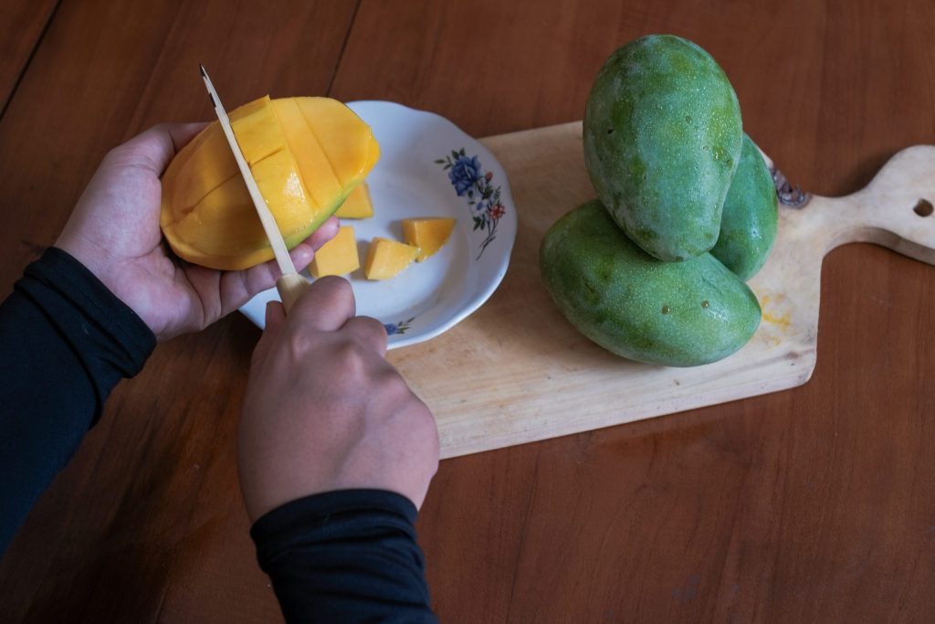 person-cutting-up-fruit-cutting-board-with-knife-scaled.jpg